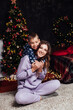 © dmitriisimakov - Mom with son at christmas tree with gifts garland winter