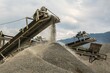 © Wirestock - A photograph of the heavy machinery at the quarry, rocks and sand conveyor belt.