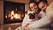 Beautiful couple in white sweaters cuddles with a dog while sitting in front of the fireplace.