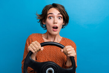 Poster - Photo portrait of lovely young lady hold steering wheel terrified wear trendy brown garment isolated on blue color background