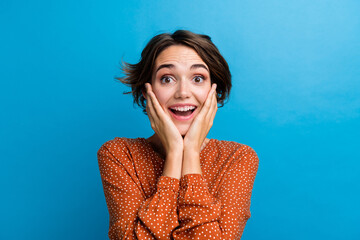 Poster - Photo of young cheery girl holding arms on her cheeks open mouth wear glamour blouse isolated over blue color background