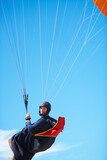 Man, portrait and paragliding in blue sky parachute for adventure fun, clouds or explore city. Male person, face and outdoor courage for fearless athlete or landing equipment, air safety in nature