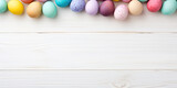 Fototapeta  - Pastel coloured Easter Egg banner, pastel eggs against a pastel wood background. Copy space.
