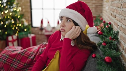 Sticker - Young hispanic woman celebrating christmas with sad expression at home