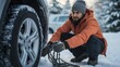 Man putting snow chains on car tire