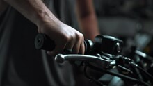 Men's Hands Start Motorcycle In Dark Workshop Holding Gas Handle