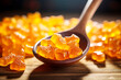 Orange chewy gummy candies with turmeric extract on a wooden background.