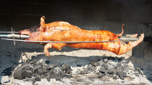 Pig Carcass On A Spit Roasted Over An Open Fire.