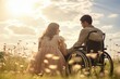 A woman with her disabled husband in a wheelchair in the countryside at sunset