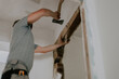 © Nataliya - A young Caucasian male builder clears a doorway using a crowbar.
