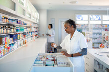 Pharmacist Examining Medication in Pharmacy