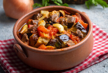 Wall Mural - Top view of Turkish dish Guvech - baked meat with eggplant and traditionally served in earthenware pot (Turkish name; etli patlican guvec)