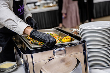 chef in hotel kitchen preparing food, catering service and people concept