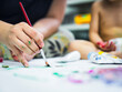 © sommart - Children and mother painting images with water color on the paper and making prints by hands and foots.