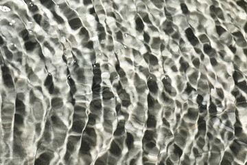 Wall Mural - Rippled surface of clear water on light grey textured background, top view