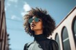 Low angle view of stylish woman with curly hair wearing sunglases