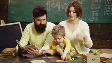 Fototapete - Cute clever boy study. Family playing at home. Parents helping children with their homework at home. Baby with the help of dad and mom.