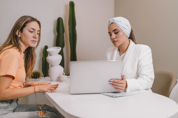 Woman talking to a beautician doctor in the office