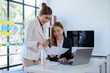© amnaj - Two Asian business woman are talking and consulting at office.