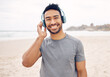 © Azeemud/peopleimages.com - Smile, headphones and portrait of man on the beach running for race, marathon or competition training. Happy, fitness and young male athlete listen to music, radio or playlist for exercise by ocean.