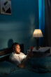 © Andrii Lysenko - Addicted man using his mobile phone in the bed suffering from insomnia at night