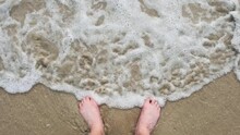 Bare Feet Are Washed By The Waves Of The Sea Or Ocean. Finally Some Rest And Relaxation