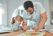 © K Davis/peopleimages.com - Father, girl and writing in book for homework, teaching or helping child in support at home. Dad or parent drawing with little kid for learning, education or homeschooling together on table at house