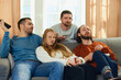 Group portrait of young people, lovely couple with friends, with unhappy faces sitting on sofa unhappy with premise of drama series