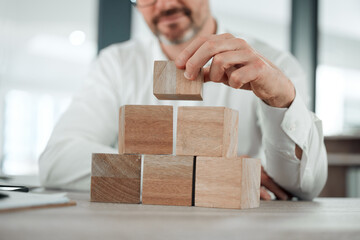 Building blocks, hands and business man in office for future planning, insurance or finance. Wood, puzzle and closeup of male entrepreneur with asset management, investment or financial security