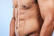 Studio water drops, body shower and person wet, grooming or morning care, maintenance or cleaning torso abs muscle. Bathroom liquid, strong stomach and closeup model hygiene wash on blue background