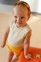 Wall Mural - Closeup portrait of a cute little girl posing in studio, isolated beige background.