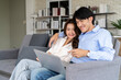 © pixs4u - Young couple planning future together on couch with Laptop internet