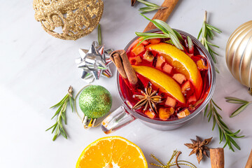 Wall Mural - Traditional Christmas aromatic mulled wine cocktail, red wine grog tea drink with spices, cinnamon, orange and rosemary sprig, on Christmas New Year decorated wooden cozy background