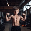 Little preschool boy with naked torso showing strong biceps. Generative AI