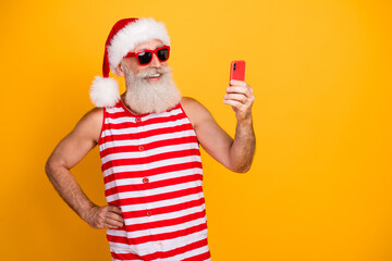 Poster - Photo of funky cheerful senior guy christmas swimwear hat glasses texting twitter telegram empty space isolated yellow color background