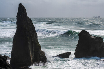 Wall Mural - Rock formation on reykjanes peninsula on iceland with waves and a ship in the background- valahnúkamöl