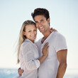 © Mariusz S/peopleimages.com - Couple, beach portrait and hug with love, support and care on a date by the sea with romance on vacation. Holiday, ocean and outdoor with summer travel in nature relax on a break and trip by water
