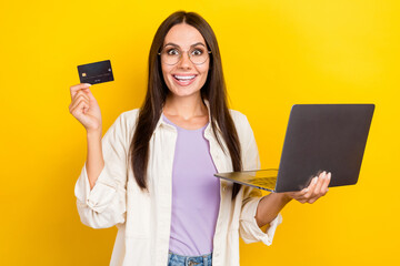 Sticker - Photo portrait of pretty young girl hold netbook excited credit card wear trendy white outfit isolated on yellow color background