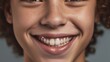 © iuricazac - Cheerful teen boy grins, his teeth shining against a clear, beige setting.