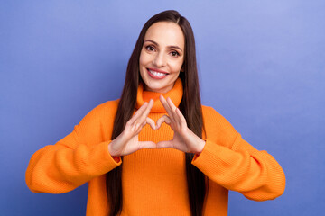 Canvas Print - Portrait of charming mature woman in orange pullover show heart figure sign love valentine day symbol isolated on purple color background