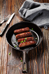 Wall Mural - fried sausages on black cast iron pan