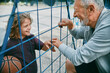 © Marko Geber - Grandfather and Grandson Sharing a Moment on the Basketball Court