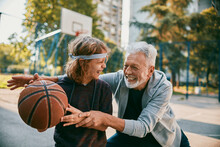 Grandfather And Grandson Playing Basketball On An Outside Basketball Park