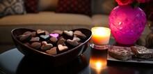 A side table with heart-shaped coasters and a bowl of chocolate truffles.
