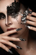 Portrait of a beautiful woman with art make-up, creative long nails. Design manicure. Beauty face.