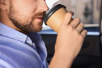 Canvas Print - To-go drink. Man drinking coffee in car, closeup