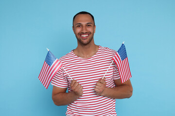 Wall Mural - 4th of July - Independence Day of USA. Happy man with American flags on light blue background