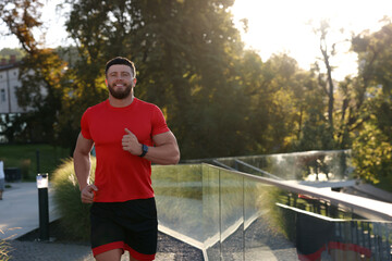 Canvas Print - Happy man running outdoors on sunny day. Space for text