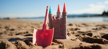 Fun In The Sun: Pink Sandcastle And Shovel On Beach