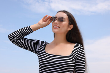 Sticker - Beautiful smiling woman wearing stylish sunglasses outdoors